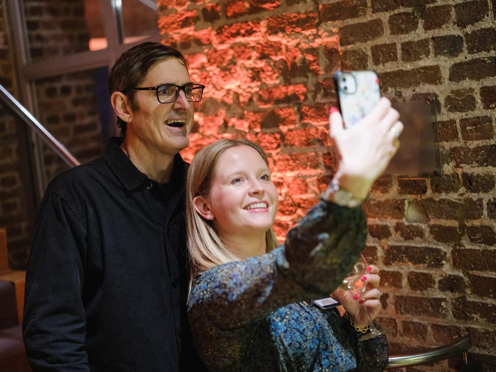 event photography of a guest taking a selfie with Louis Theroux