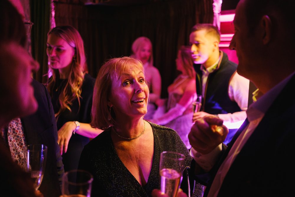 Group of party guests laughing together in the main lounge at Dear Darling, Mayfair