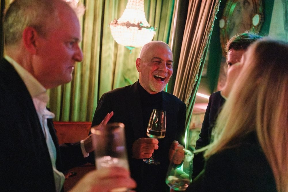 Candid moment of guests reacting to a magician’s trick at a Mayfair birthday party