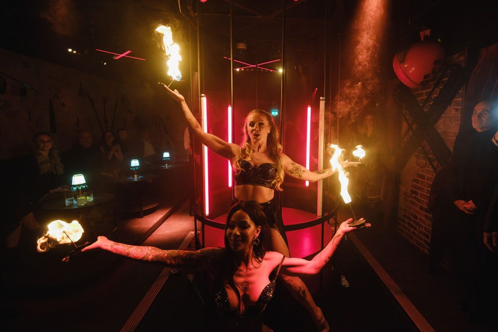 Action shot of a flame dancer entertaining guests at a Mayfair nightclub event