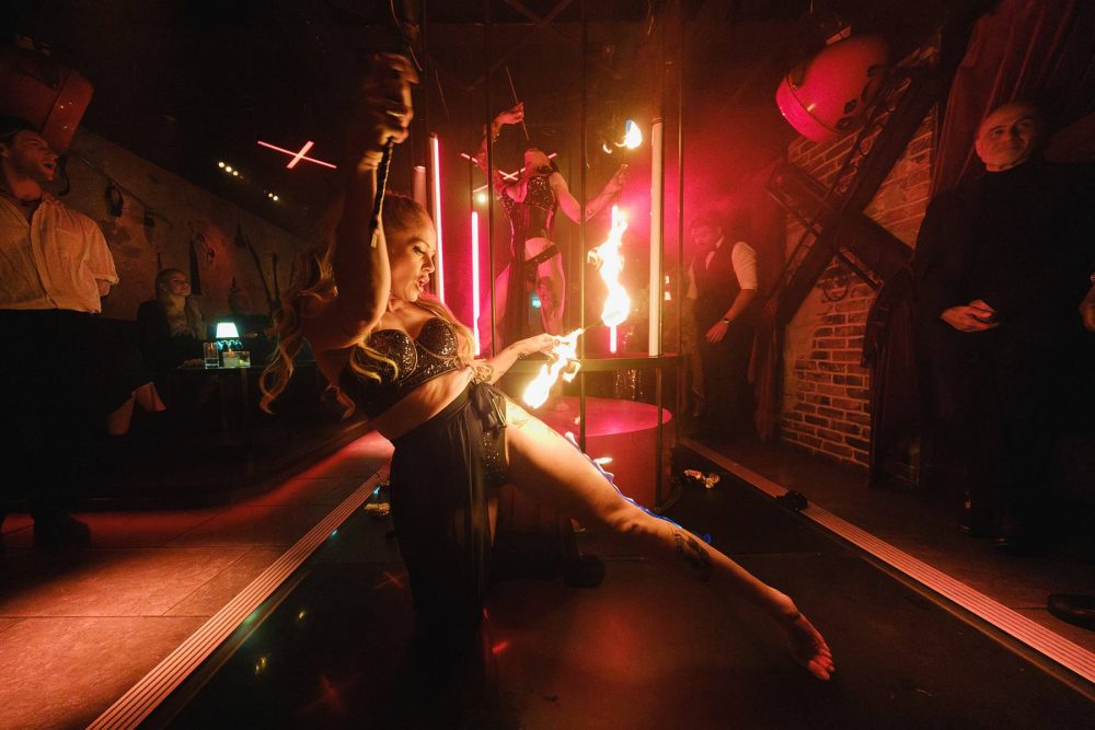 Action shot of a flame dancer entertaining guests at a Mayfair nightclub event