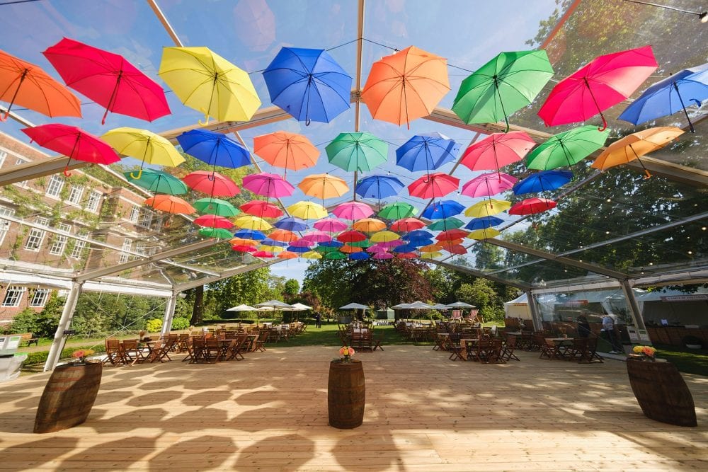 Covered decking at Regent’s University with colourful umbrellas and flowers for summer event