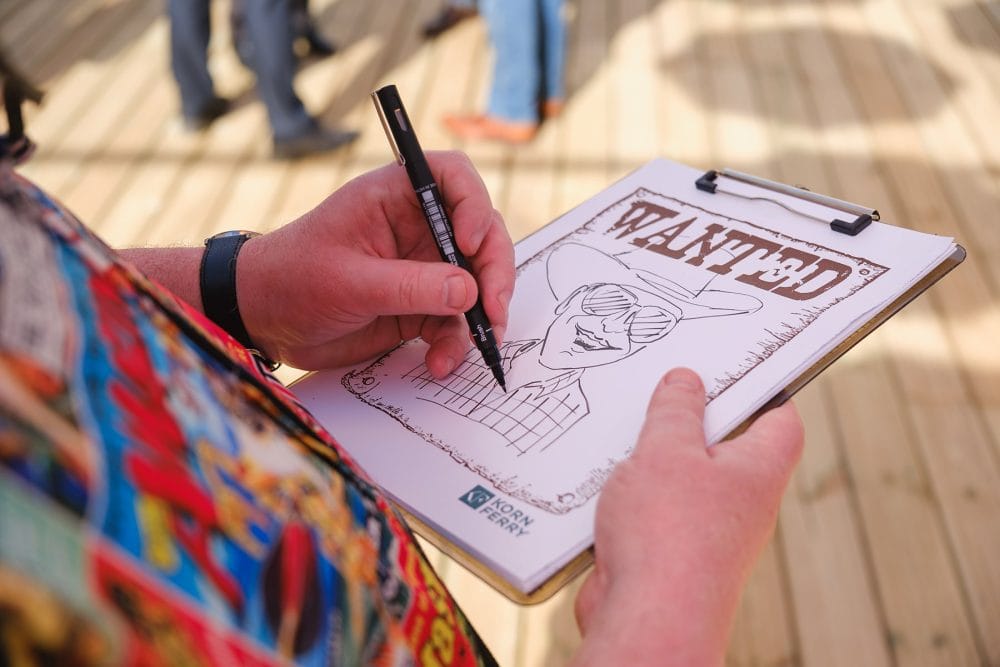 Closeup of caricature artist sketching guest during summer event