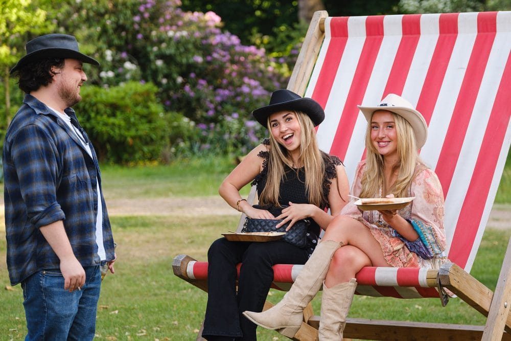 guests enjoying the street food in the oversized deck chairs at a summer party at regent's university