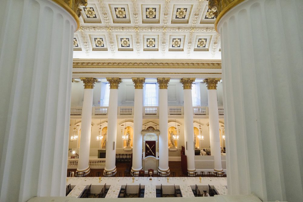 Wide shot of the Egyptian Hall at Mansion House from balcony level, set up for an anniversary dinner