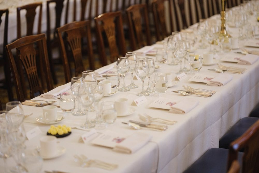 Close-up of table settings in the Egyptian Hall at Mansion House, including cutlery, glasses, and centerpieces.