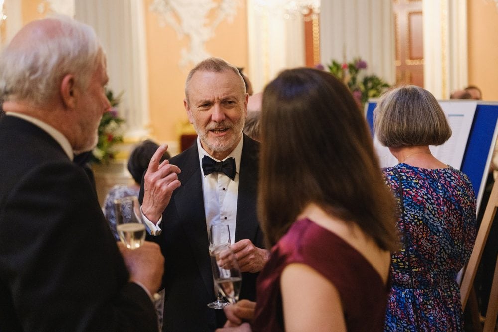 Candid photograph of guests laughing and chatting during a Mansion House reception