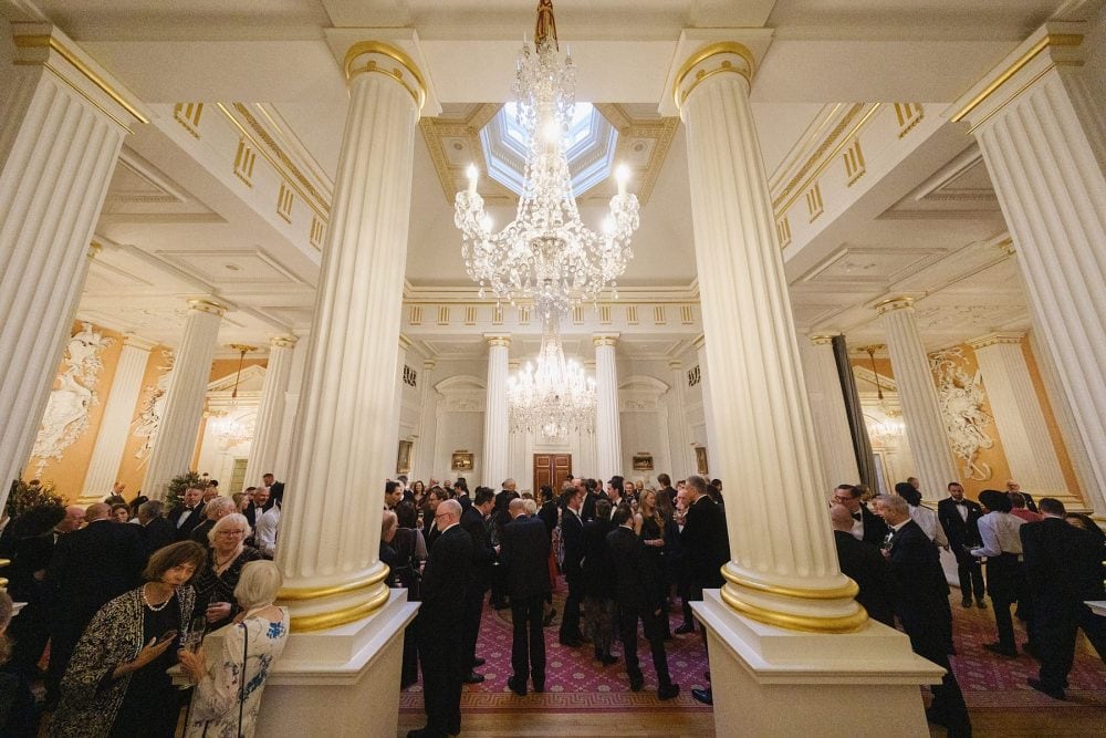 Wide shot of guests mingling and enjoying drinks at the Mansion House Salon reception