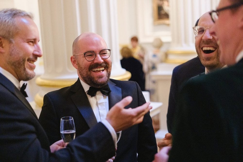 Another candid photo of guests socialising and laughing in the Mansion House Salon