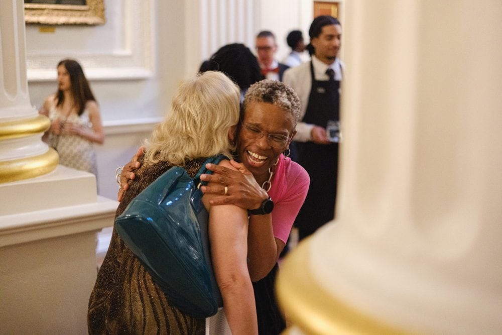 Candid image of two guests hugging and greeting each other at the Mansion House reception