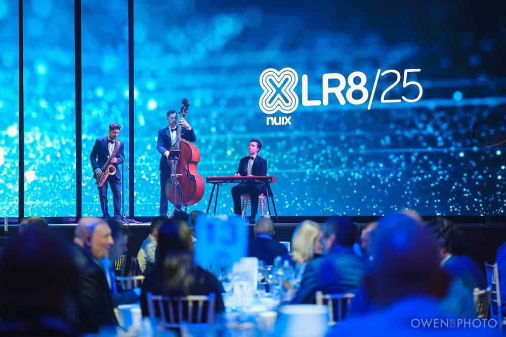 Live music performance by a three-piece band at Vision Hall