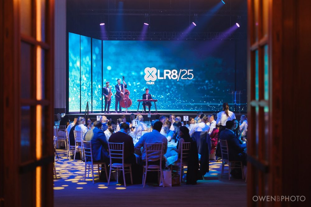 a wide shot of live music performance by a three-piece band at Vision Hall
