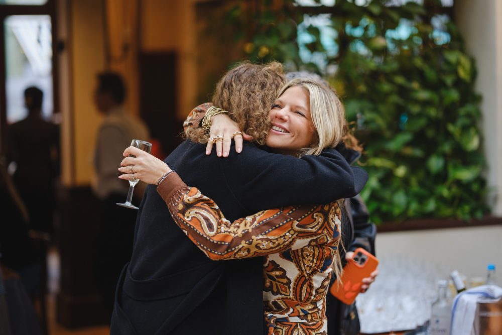 Friends hugging and greeting each other at a Lemonia event