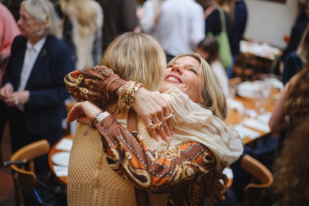Friends hugging and greeting each other at a Lemonia birthday lunch