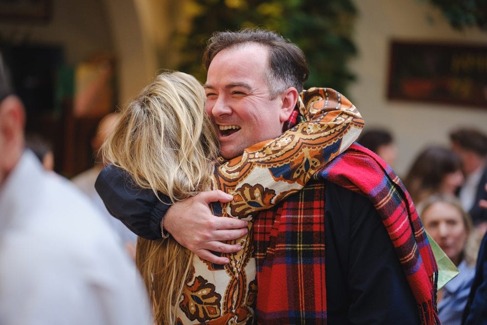 Friends hugging and greeting each other at a Lemonia event