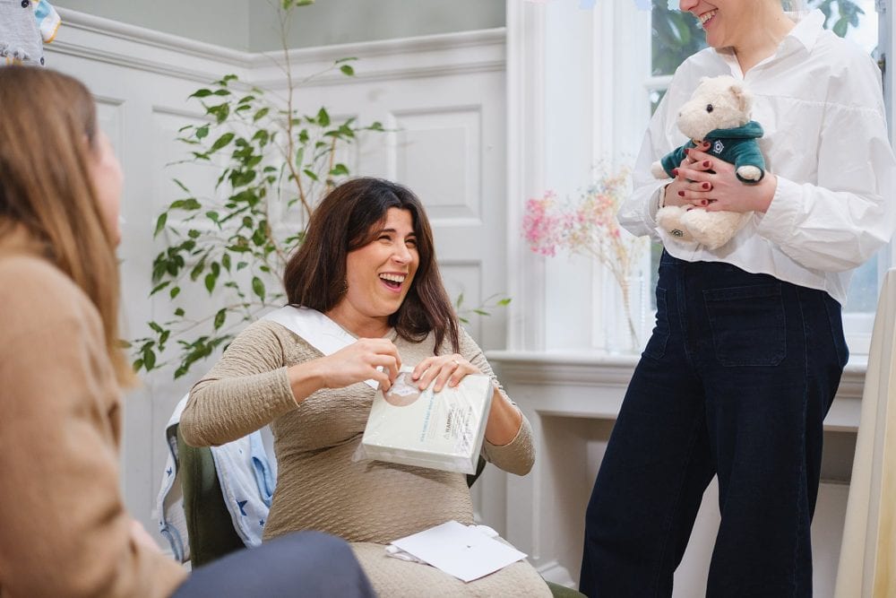 Guest of honour opening presents captured during a baby shower