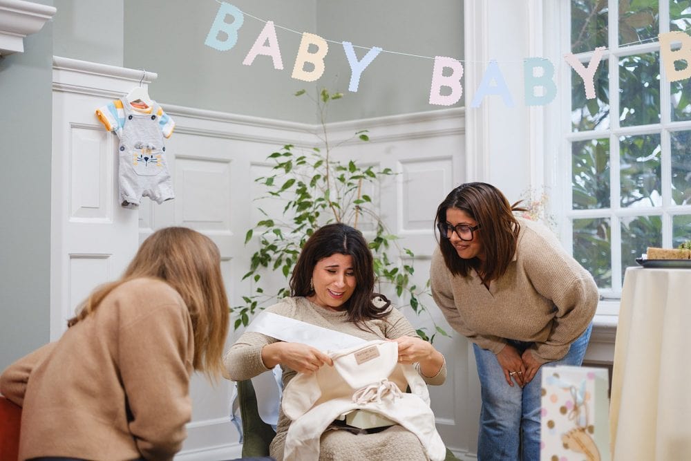 The expectant mother opening a gift, photographed at the party