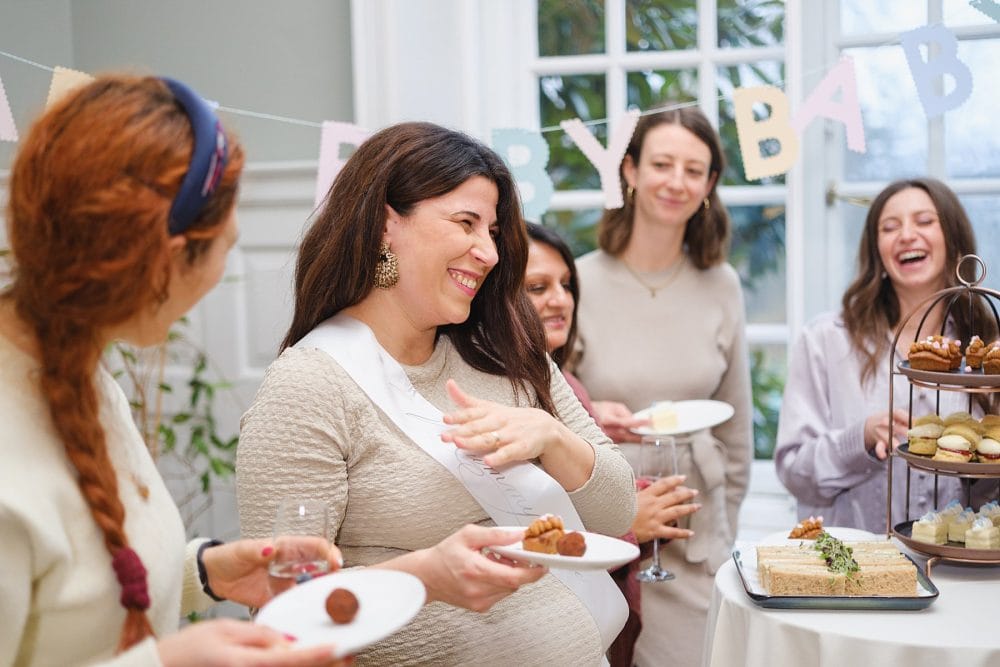 Baby shower guests enjoying cakes and treats, photographed at the event