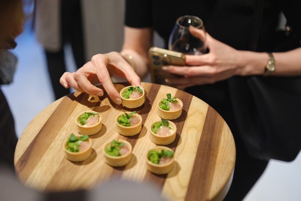 guest picking up a canape, photographed for a showroom launch event