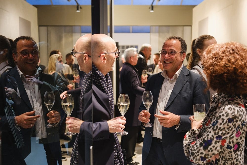guests photographed for a showroom launch event, reflected in the glass walls