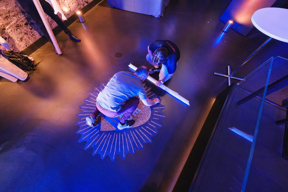 crew setting up logos on the floor for an event at London Science Museum