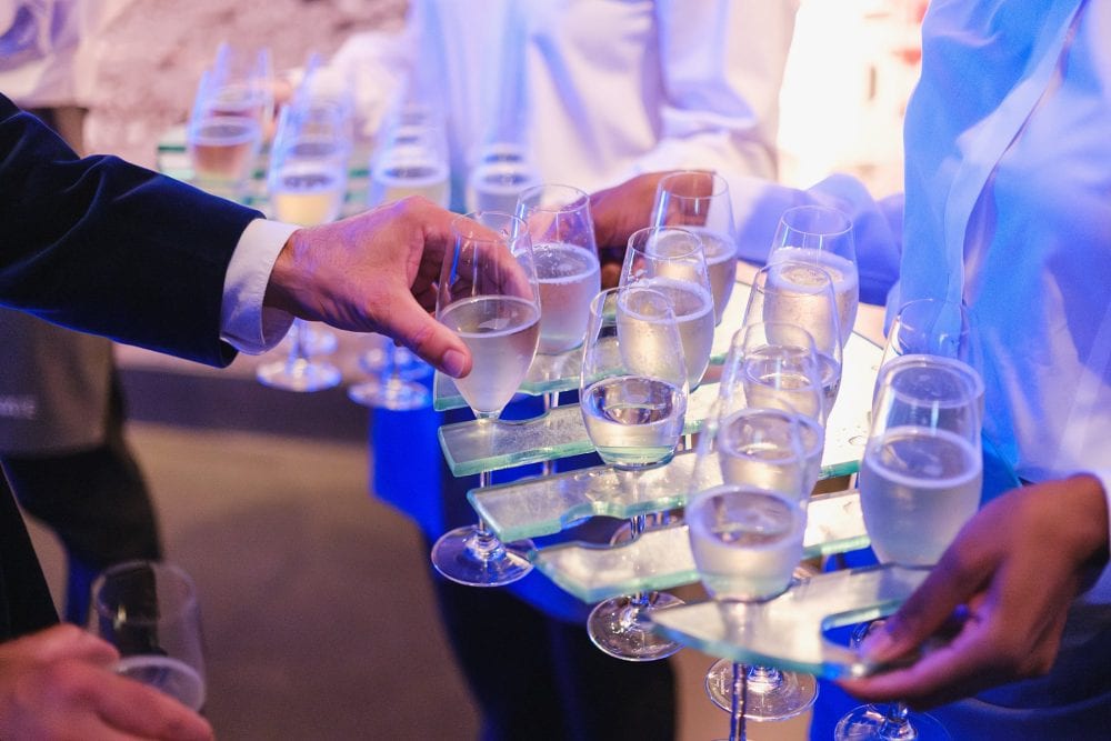 guests collecting champagne on arrival to an event at London Science Museum